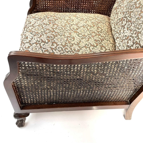 1892 - A walnut framed three piece Bergere suite. Circa 1920, with loose cushions on carved ball and claw f... 