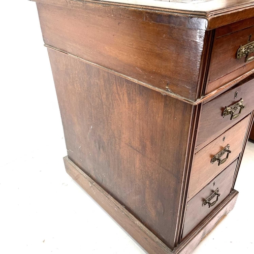 1893 - A late Victorian walnut kneehole desk. With an arrangement of nine drawers on a plinth base and cast... 