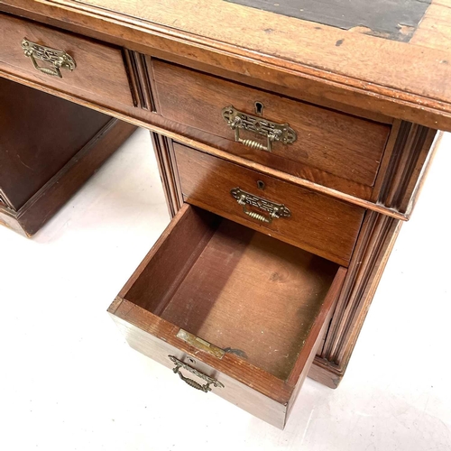 1893 - A late Victorian walnut kneehole desk. With an arrangement of nine drawers on a plinth base and cast... 