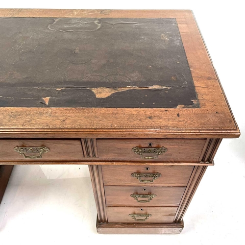 1893 - A late Victorian walnut kneehole desk. With an arrangement of nine drawers on a plinth base and cast... 