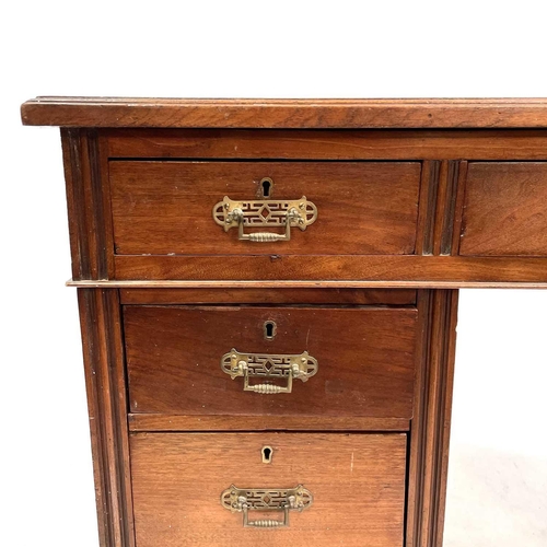 1893 - A late Victorian walnut kneehole desk. With an arrangement of nine drawers on a plinth base and cast... 