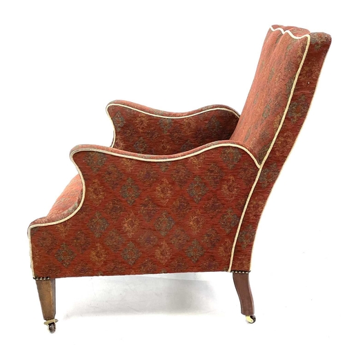 1896 - An Edwardian mahogany framed armchair. With shaped back and arms on square taper legs and castors, o... 