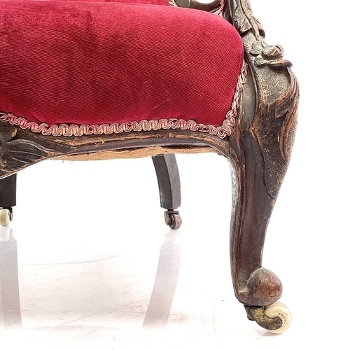 1900 - A Victorian walnut framed spoon back armchair. With buttoned upholstery and raised on carved cabriol... 