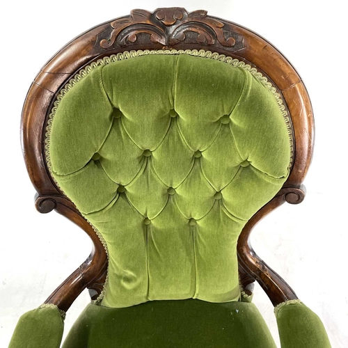 1910 - A Victorian walnut framed spoon back armchair. With button back and raised on carved cabriole legs, ... 