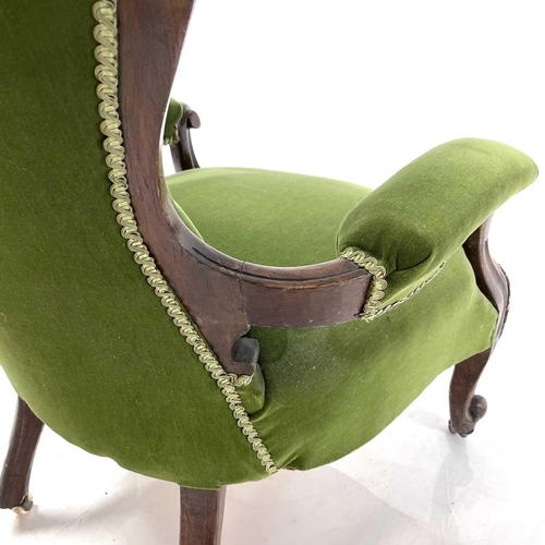 1910 - A Victorian walnut framed spoon back armchair. With button back and raised on carved cabriole legs, ... 