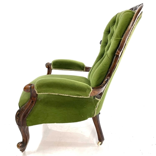 1910 - A Victorian walnut framed spoon back armchair. With button back and raised on carved cabriole legs, ... 