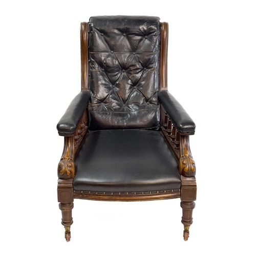 1917 - A Victorian leather upholstered walnut armchair. With buttoned back, the padded arms with spindle tu... 