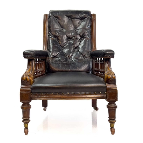 1917 - A Victorian leather upholstered walnut armchair. With buttoned back, the padded arms with spindle tu... 