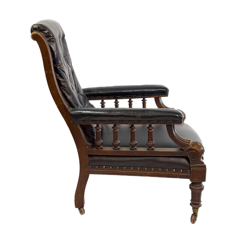 1917 - A Victorian leather upholstered walnut armchair. With buttoned back, the padded arms with spindle tu... 