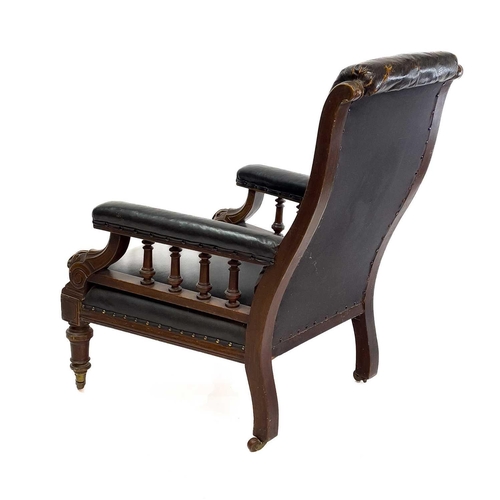 1917 - A Victorian leather upholstered walnut armchair. With buttoned back, the padded arms with spindle tu... 