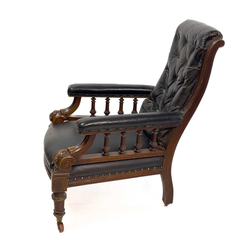 1917 - A Victorian leather upholstered walnut armchair. With buttoned back, the padded arms with spindle tu... 