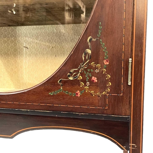 1920 - An Edwardian mahogany inlaid and painted display cabinet. With an oval glazed door enclosing three s... 