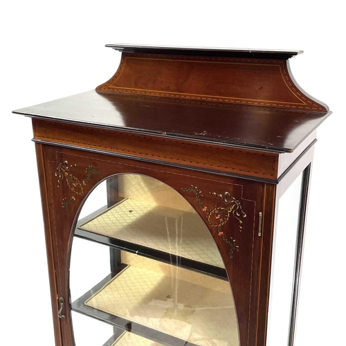 1920 - An Edwardian mahogany inlaid and painted display cabinet. With an oval glazed door enclosing three s... 