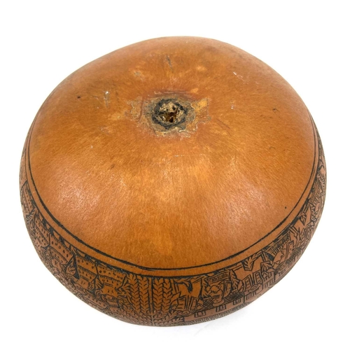 272 - A Peruvian gourd box and cover. 20th century, with finely incised decoration of figures, buildings a... 