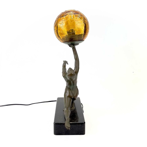 273 - An Art Deco style table lamp. Modelled as a female figure holding an amber glass ball, on a rectangu... 