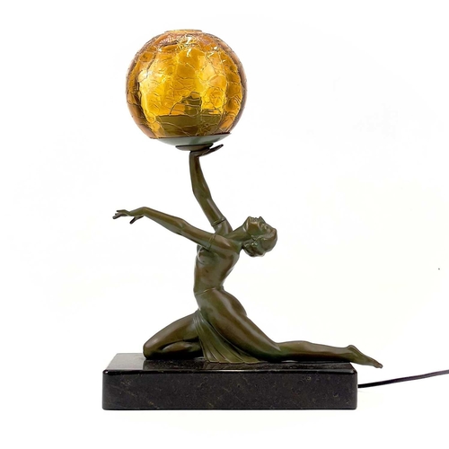 273 - An Art Deco style table lamp. Modelled as a female figure holding an amber glass ball, on a rectangu... 