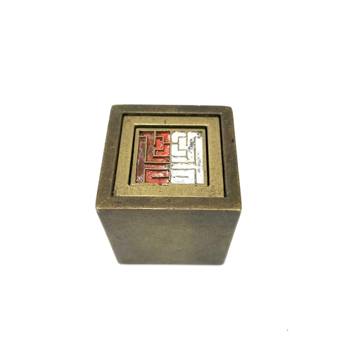 309 - A Chinese brass seal cube. With an inner fitted brass cube and interchangeable seal marks.