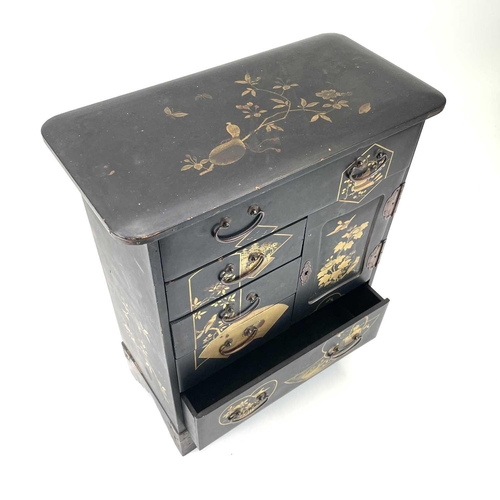 318 - A Japanese black lacquered small cabinet. Circa 1920, with gilt decoration and fitted a door and an ... 