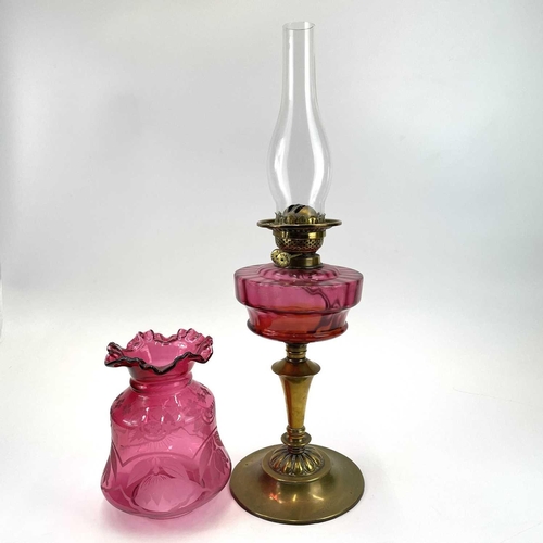 333 - A Victorian cranberry glass oil lamp, With an etched cranberry shade, on a brass base, height 62cm.