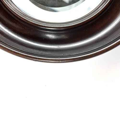 40 - A small late 19th century circular bevelled edge mirror in a mahogany frame. Diameter 20.5cm.