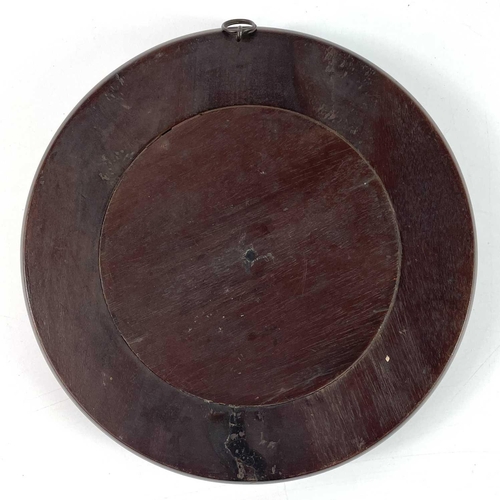 40 - A small late 19th century circular bevelled edge mirror in a mahogany frame. Diameter 20.5cm.