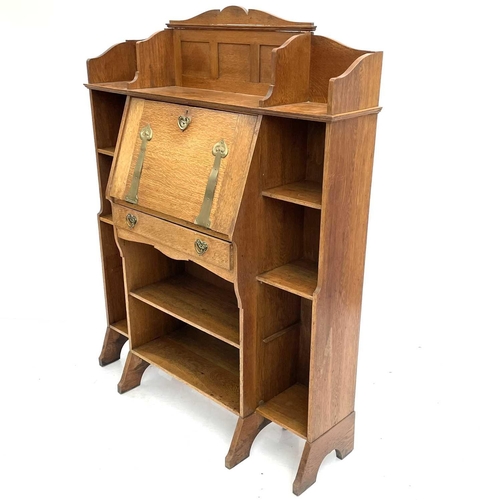 401 - An Arts and Crafts oak bureau cabinet. Circa 1900, the central fall with brass hinges and handle pie... 