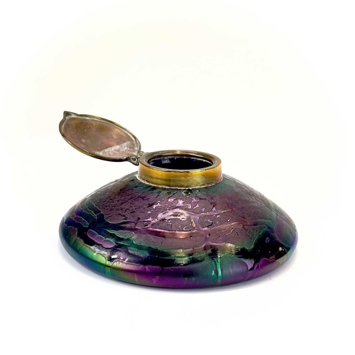 413 - An Art Nouveau Loetz type iridescent circular glass inkwell. With trailed decoration and embossed br... 