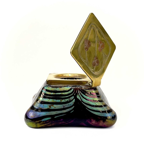 415 - An iridescent glass inkwell, probably Loetz. The lozenge shape brass cover inlaid in copper with ber... 