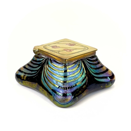 415 - An iridescent glass inkwell, probably Loetz. The lozenge shape brass cover inlaid in copper with ber... 