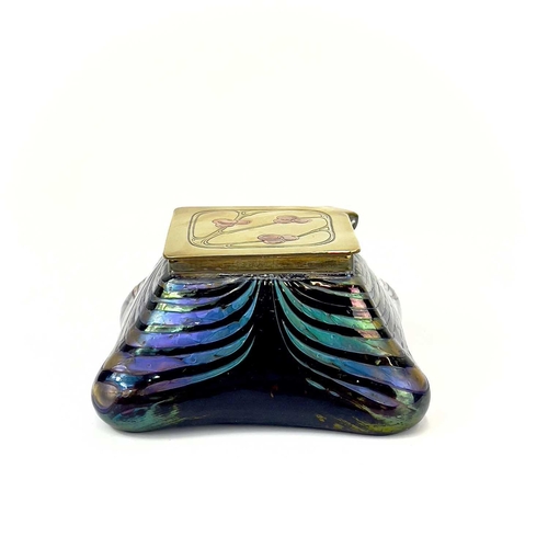 415 - An iridescent glass inkwell, probably Loetz. The lozenge shape brass cover inlaid in copper with ber... 