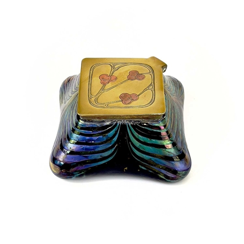 415 - An iridescent glass inkwell, probably Loetz. The lozenge shape brass cover inlaid in copper with ber... 