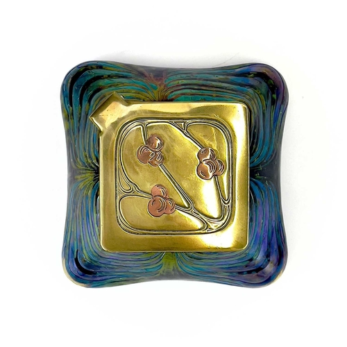 415 - An iridescent glass inkwell, probably Loetz. The lozenge shape brass cover inlaid in copper with ber... 