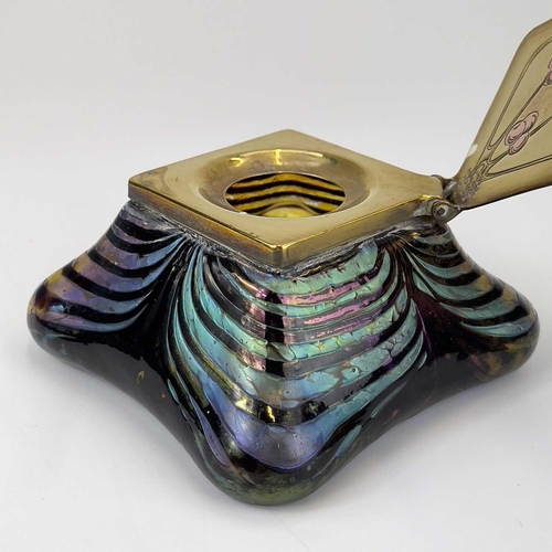 415 - An iridescent glass inkwell, probably Loetz. The lozenge shape brass cover inlaid in copper with ber... 