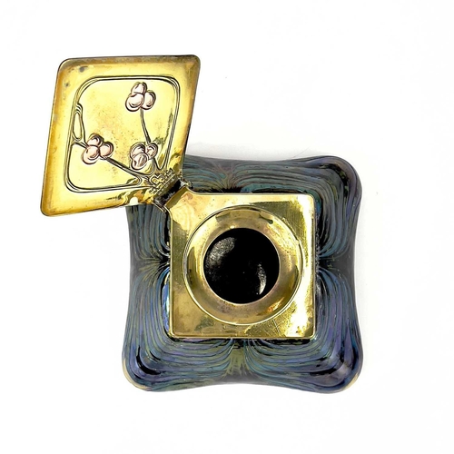 415 - An iridescent glass inkwell, probably Loetz. The lozenge shape brass cover inlaid in copper with ber... 