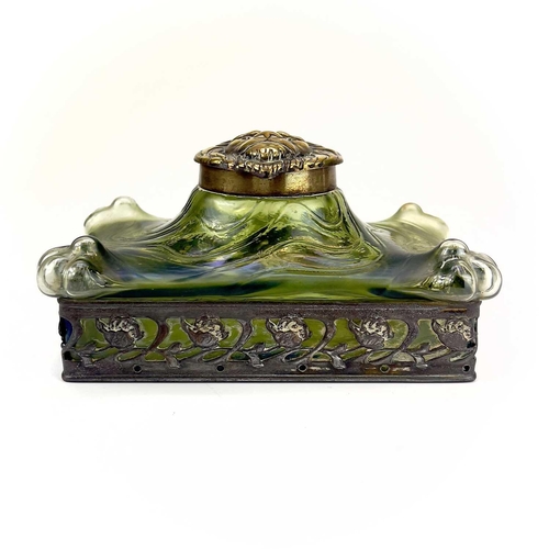 419 - A remarkable iridescent glass inkwell, probably Loetz. The brass cover embossed with a lion mask, th... 