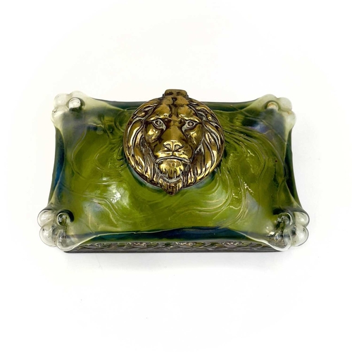 419 - A remarkable iridescent glass inkwell, probably Loetz. The brass cover embossed with a lion mask, th... 