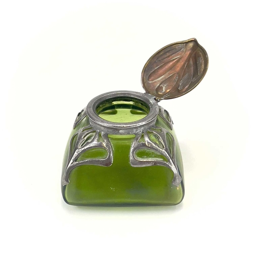 420 - An Art Nouveau iridescent green glass inkwell. Of square section, with embossed brass cover and pier... 