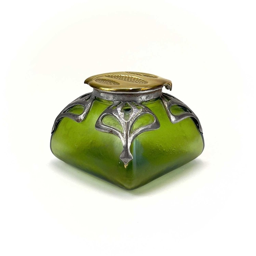 420 - An Art Nouveau iridescent green glass inkwell. Of square section, with embossed brass cover and pier... 