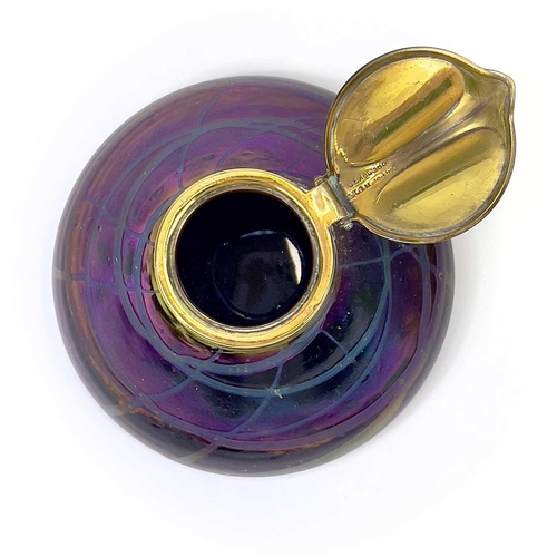 421 - A Loetz type iridescent glass circular inkwell. With trailed decoration and brass cover, height 6.5c... 