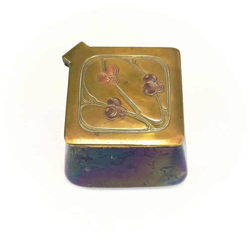 422 - A Loetz type iridescent glass inkwell. Of lozenge shape, the brass cover with copper inset fruiting ... 