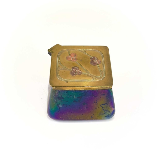 422 - A Loetz type iridescent glass inkwell. Of lozenge shape, the brass cover with copper inset fruiting ... 