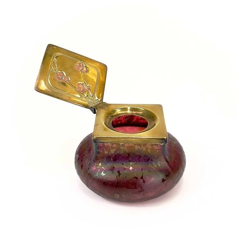 423 - A Loetz type ruby iridescent glass inkwell. The lozenge shaped brass cover inset with copper berries... 