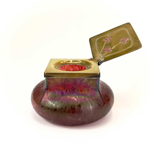 423 - A Loetz type ruby iridescent glass inkwell. The lozenge shaped brass cover inset with copper berries... 