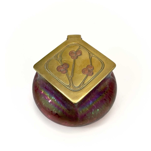 423 - A Loetz type ruby iridescent glass inkwell. The lozenge shaped brass cover inset with copper berries... 