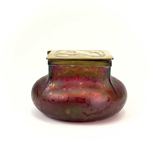 423 - A Loetz type ruby iridescent glass inkwell. The lozenge shaped brass cover inset with copper berries... 