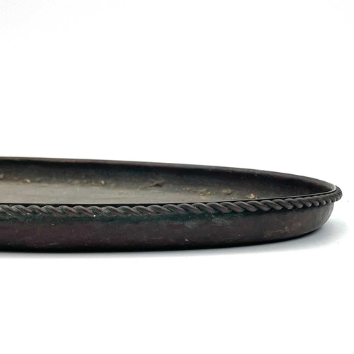 425 - A Hugh Wallis Arts and Crafts copper oval tray. With planished finish and applied rope twist border,... 