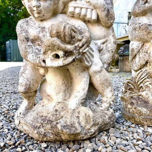 605 - A reconstituted stone fountain, modelled as putti playing pan pipes. Height 55cm together with anoth... 