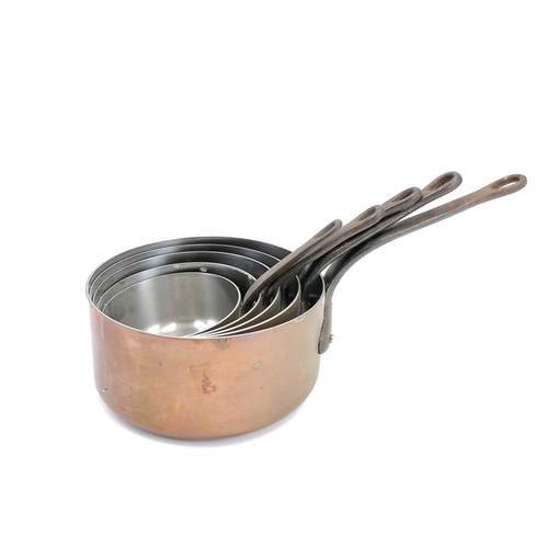 61 - A graduated set of six French copper saucepans. 20th century, with tinned interiors and steel handle... 