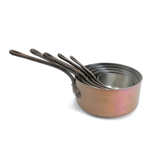 61 - A graduated set of six French copper saucepans. 20th century, with tinned interiors and steel handle... 