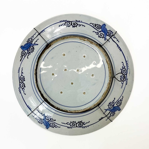 811 - A Japanese Arita blue and white charger. Circa 1900, painted with a pheasant beside a prunus tree an... 